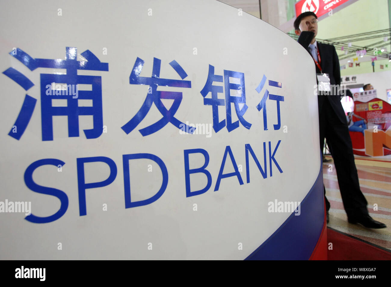 ---- Ein Mitarbeiter am Stand der SPD (Shanghai Pudong Development Bank) während einer Ausstellung in Shanghai, China, 23. November 2013 gesehen. Shangh Stockfoto