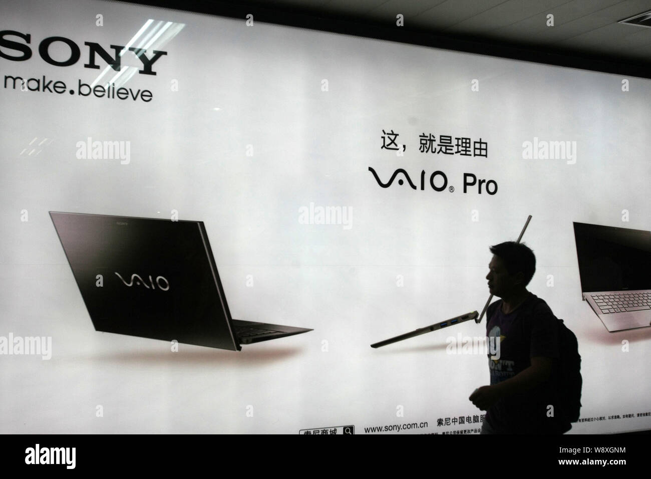 ---- Einen Fußgänger an einer Werbung für Sony VAIO Laptop Computer in Shanghai, China, 24. Oktober 2013. Japanische Elektronikkonzern S Stockfoto