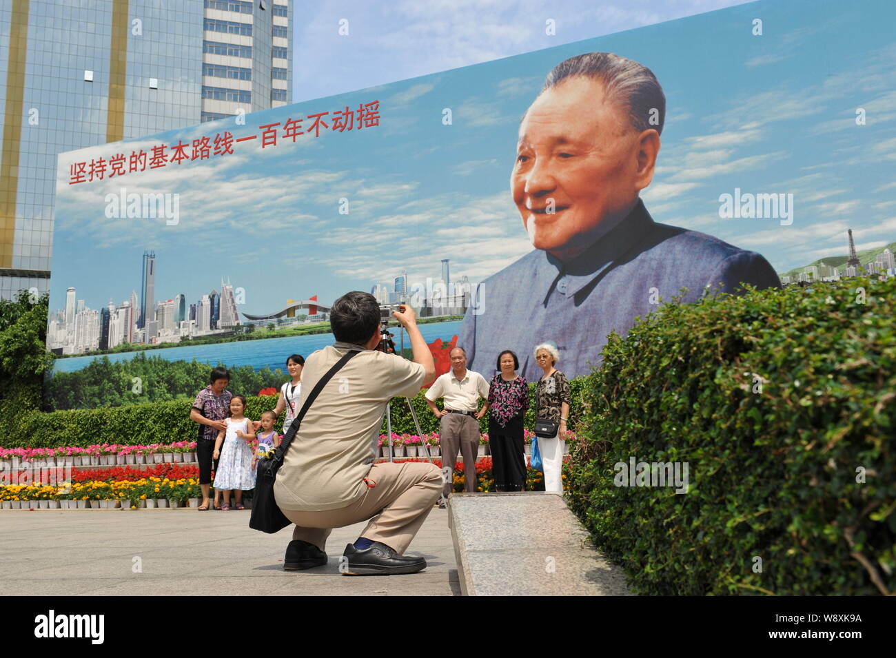 ---- Touristen für Fotos vor einem Plakat von den verstorbenen chinesischen Spitzenpolitiker Deng Xiaoping in Shenzhen City, South China Guangdong Provinz, 2 Stellen Stockfoto