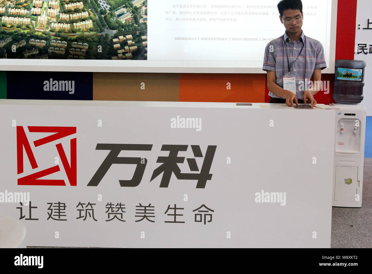 Ein Mitarbeiter ist auf dem Stand von Vanke während einer Ausstellung in Shanghai, China, 26. Mai 2014 gesehen. China größte Eigenschaft Entwickler sieht Schwachstellen in Stockfoto