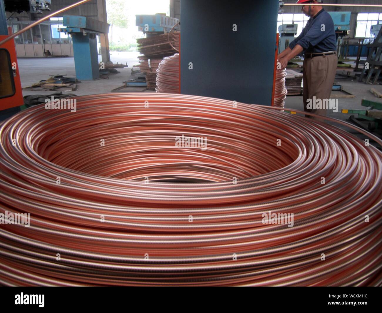 ---- Ein chinesischer Arbeiter griffe Herstellung von gewickelten Kupferrohre eine Fabrik in Nantong City, East China Jiangsu Provinz, 4. Oktober 2012. Copp Stockfoto