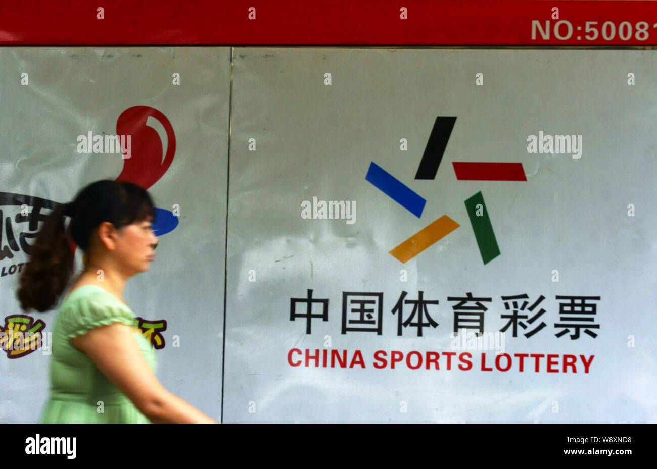 ---- Einen Fußgänger an einer Werbung für China Sport Lotterie in Kunshan City, Central China Provinz Hubei, 7. Juni 2014. Viele Milli Stockfoto