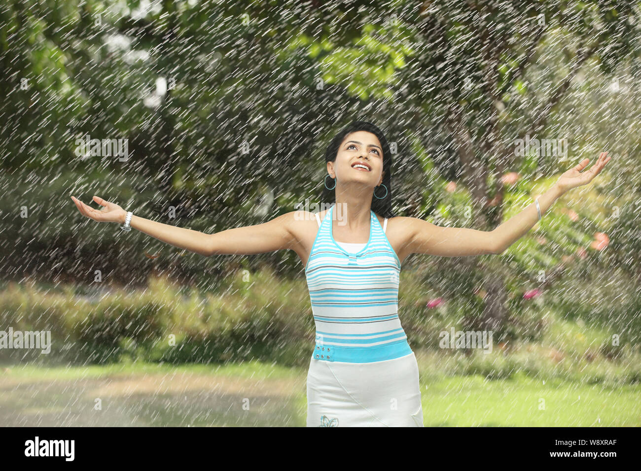 Junge Frau genießt den Regen Stockfoto