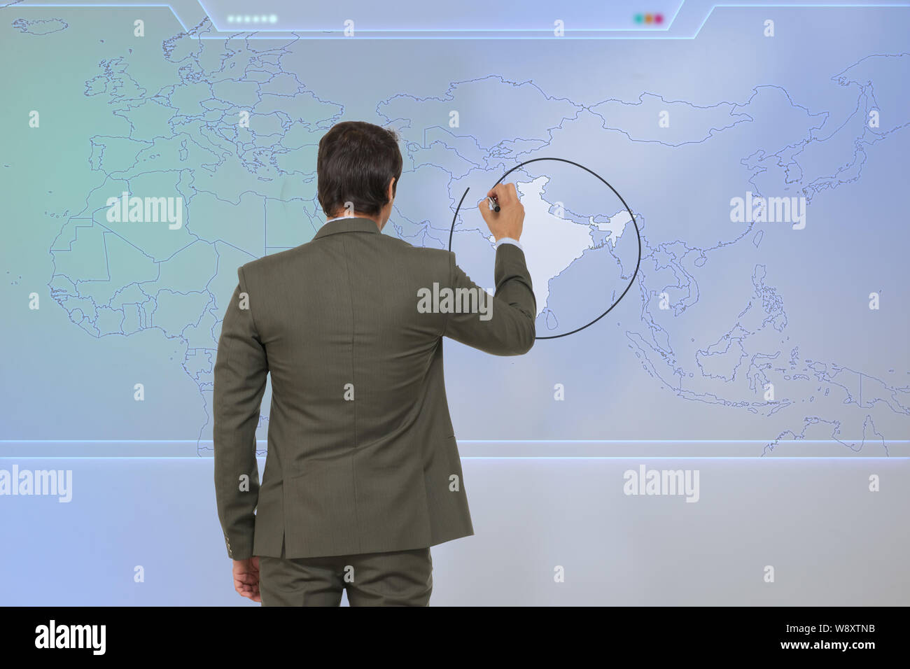 Rückansicht eines Geschäftsmannes, der die indische Karte auf dem Touchscreen markiert Stockfoto