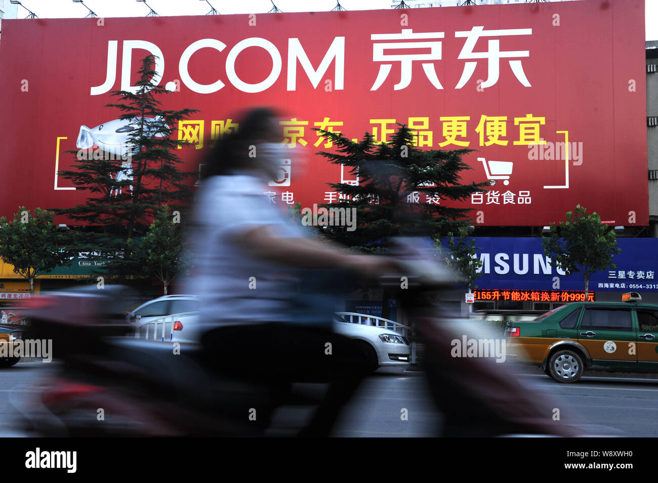 ---- Ein Radfahrer fährt Vergangenheit eine Werbung für Online shopping site JD.com, früher oder jingdong.com 360Buy.com, in Stadt Huainan, East China Stockfoto