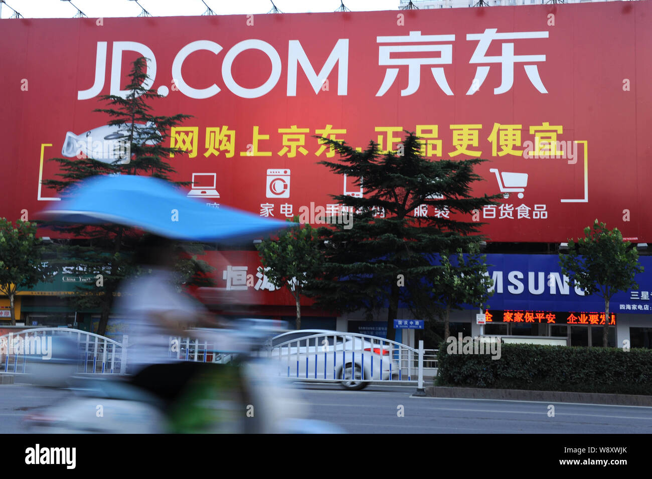 ---- Ein Radfahrer fährt Vergangenheit eine Werbung für Online shopping site JD.com, früher oder jingdong.com 360Buy.com, in Stadt Huainan, East China Stockfoto