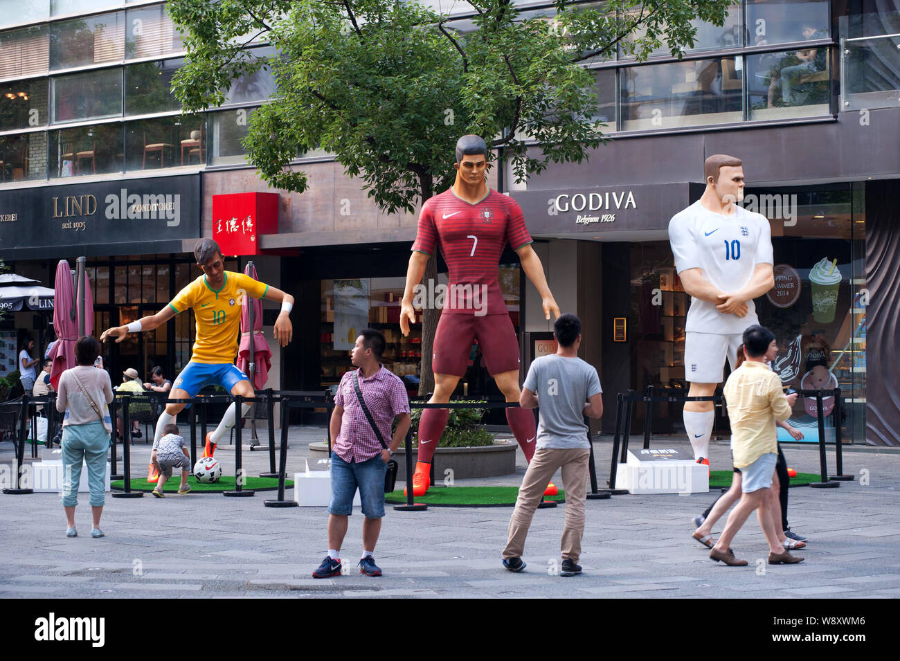 Besucher letzten drei riesige Figuren der Fußball-Superstars (von links) Neymar von Brasilien, Cristiano Ronaldo von Portugal und Wayne Rooney von England Stockfoto