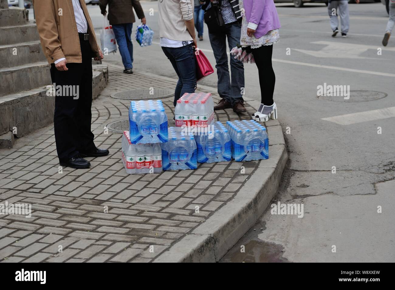Ein Anwohner steht neben Flaschen Trinkwasser, das er von einem Supermarkt nach dem Wasser Quelle für eine Leitungswasser Pflanze vergiftet von einem gekauft wurde Stockfoto