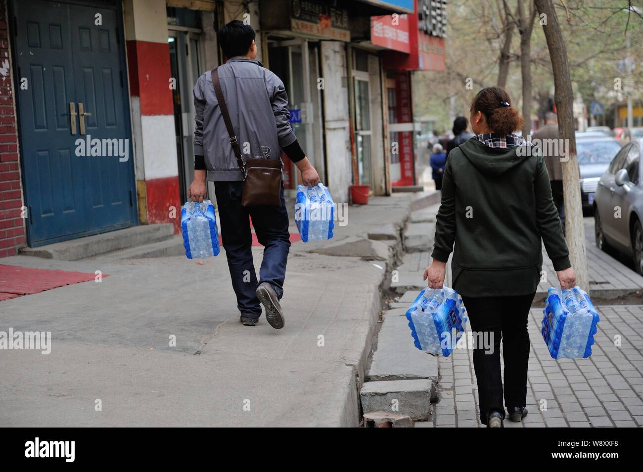 Anwohner tragen Flaschen Trinkwasser aus einem Supermarkt nach dem Wasser Quelle für eine Leitungswasser Pflanze gekauft wurde durch eine grobe oi vergiftet Stockfoto