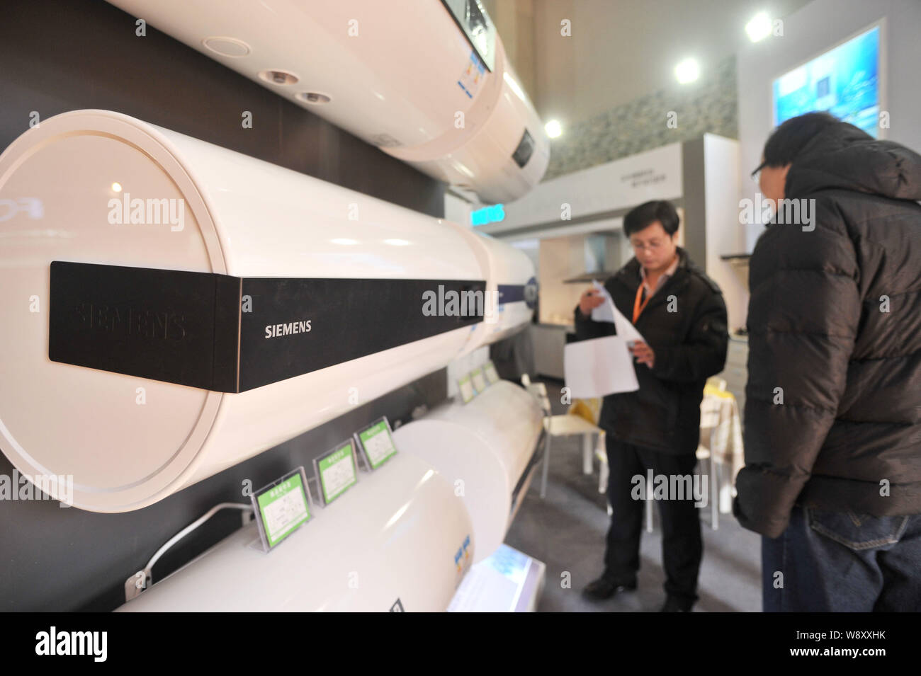 ---- Besucher Blick auf Siemens Durchlauferhitzer während einer Home Appliance Ausstellung in Peking, China, 7. März 2014. Die Siemens AG und Peking Automot Stockfoto