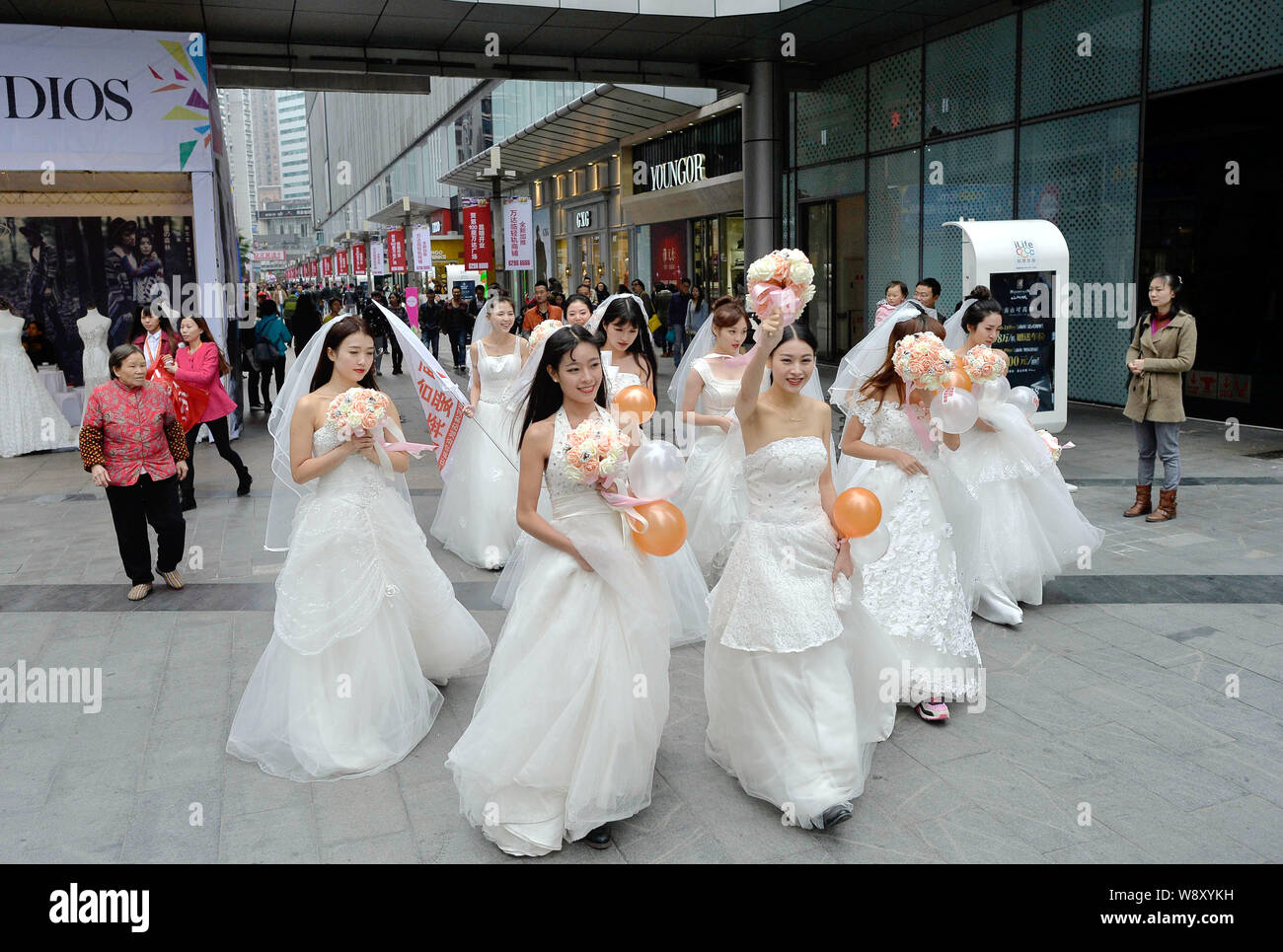 Einzelne Frauen in Hochzeit Kleider gekleidet halten Blumensträuße und Luftballons vor Singles Tag am Wanda Square in Chongqing, China, 9. November 20. Stockfoto