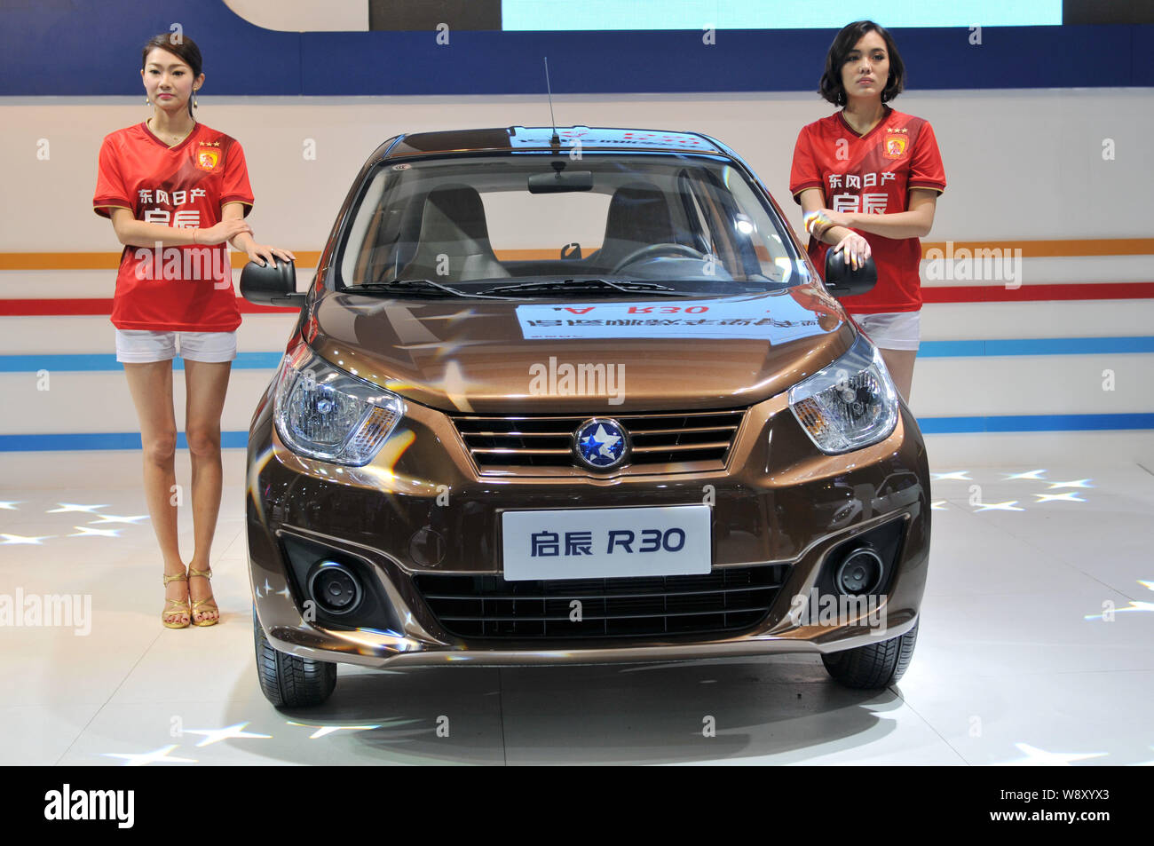 ------ Modelle posieren mit einem Venucia R 30 von Dongfeng Nissan, ein Joint Venture zwischen Dongfeng Motor und Nissan, während ein Auto Show in Shenyang City, keine Stockfoto