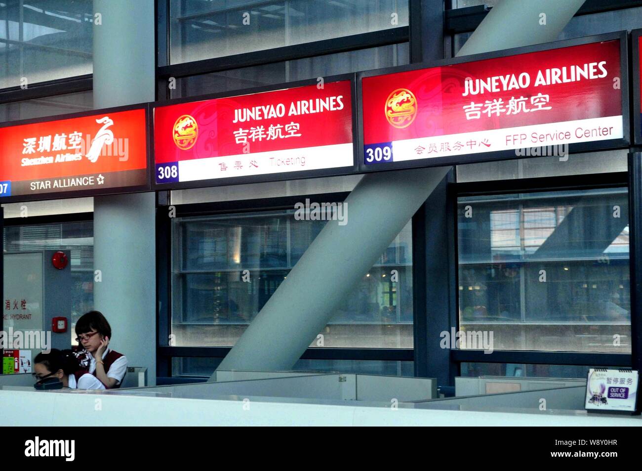 ------ Chinesische Mitarbeiter sind an der Theke der Juneyao Airlines am Flughafen in Shanghai, China, 20. Juli 2013 gesehen. Auf den Spuren der Stockfoto