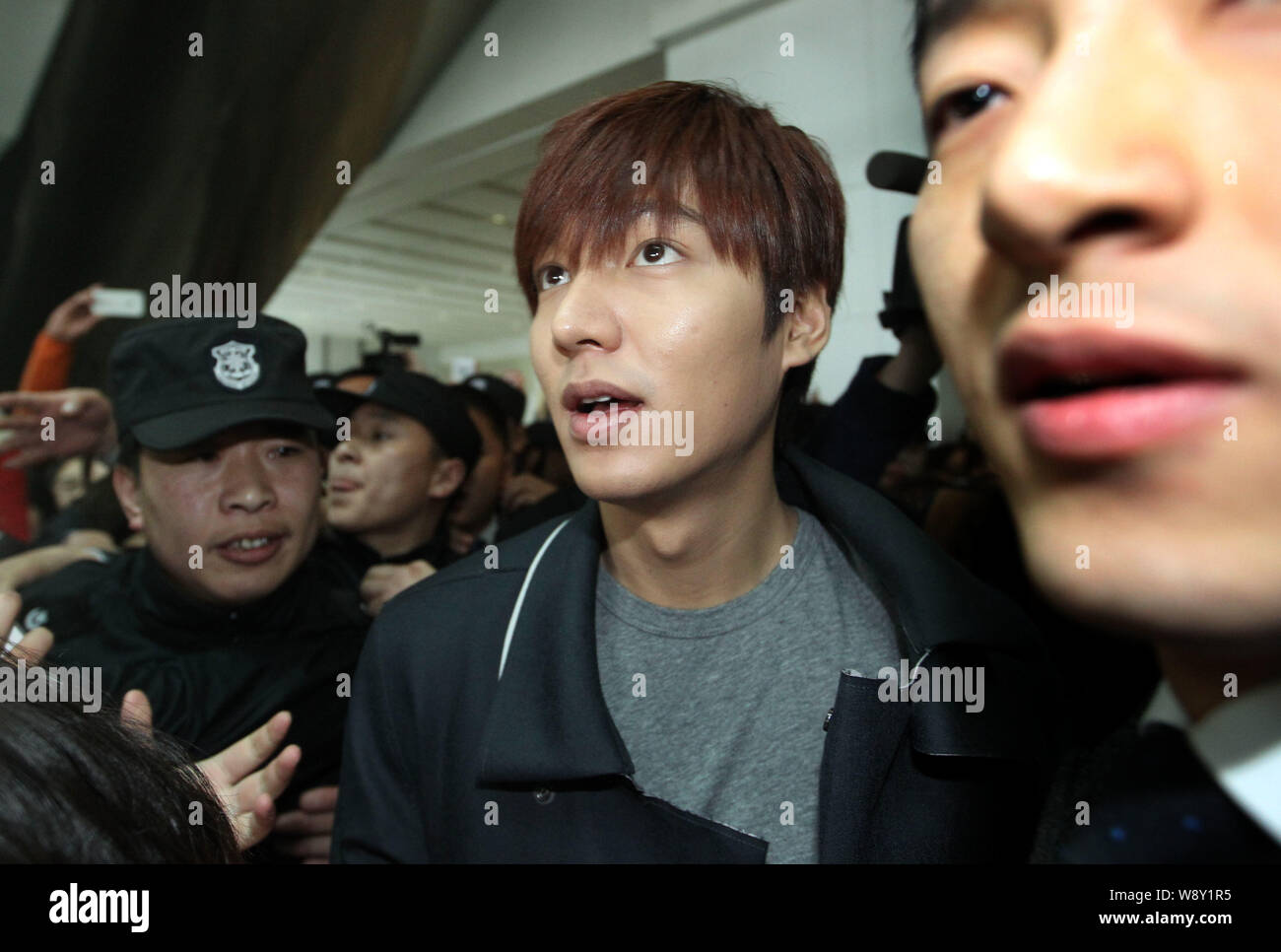 Koreanische Schauspieler Lee Min-ho, Mitte, wird von den Massen von Fans bei der Ankunft am internationalen Flughafen Hangzhou Xiaoshan in Hangzhou umgeben, Eas Stockfoto