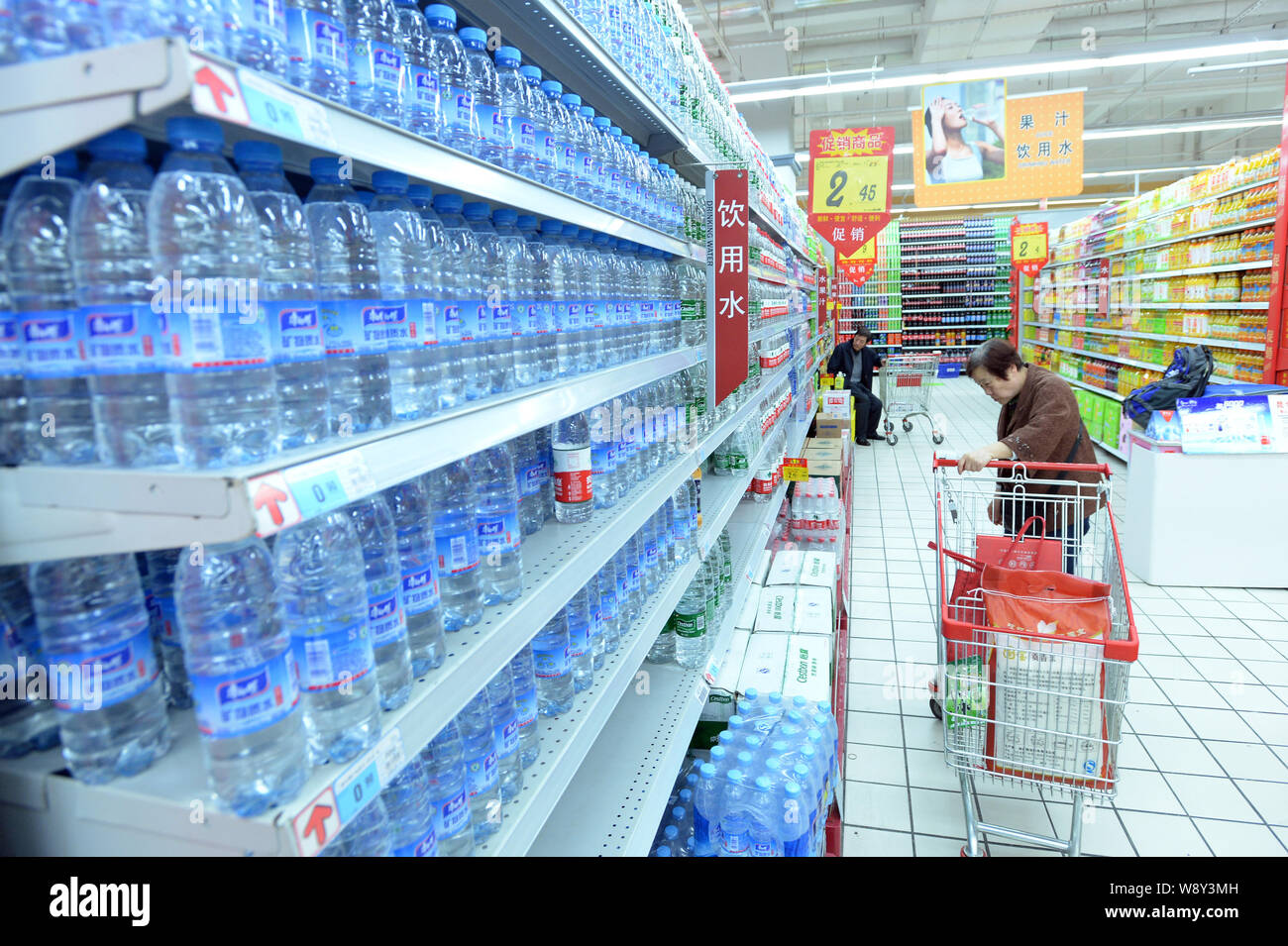 Ein Kunde sucht in Flaschen von reinem Wasser in einem Supermarkt in Wuhan City, Central China Provinz Hubei, 24. April 2014. Zwei große Wasserversorger i Stockfoto