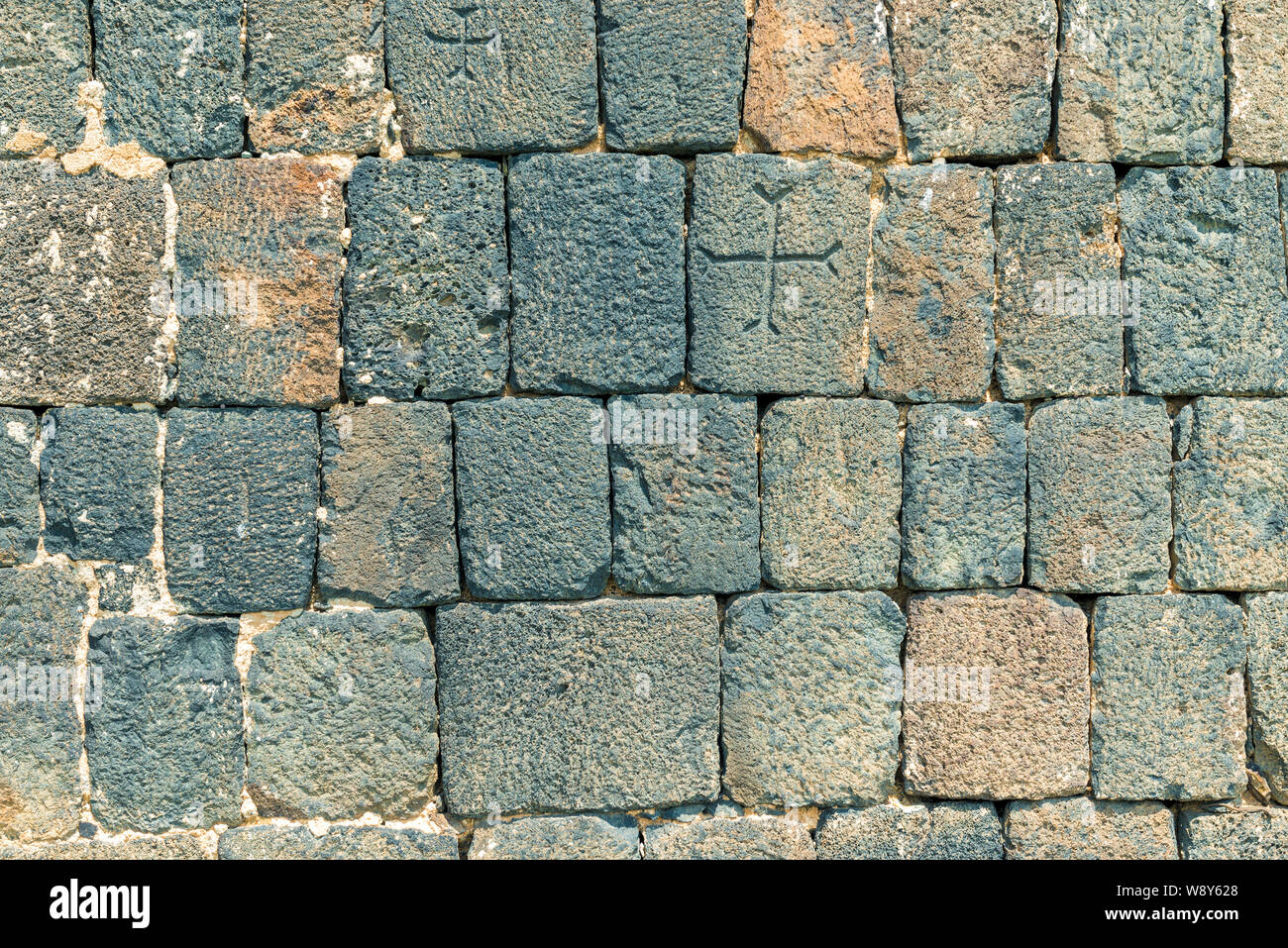 Nahaufnahme von einer Steinmauer eines armenischen Tempel mit Kreuzen Stockfoto
