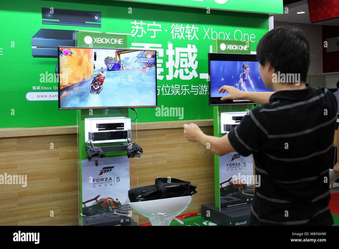 Einen Kunden spielt elektronische Spiele auf einer Xbox eine Spielkonsole zu einem suning Haushaltsgeräte in Shanghai, China, 29. September 2014. Microsoft la Stockfoto