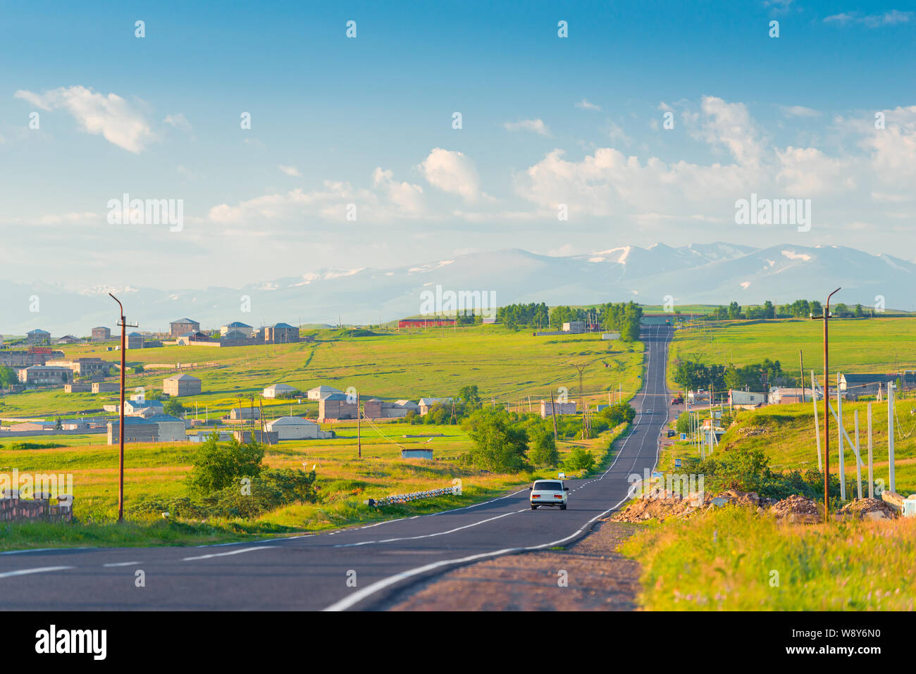 Die Straße, die armenischen Dorf und die Aussicht auf die schneebedeckten Gipfel der Berge von Armenien im Sommer morgen Stockfoto