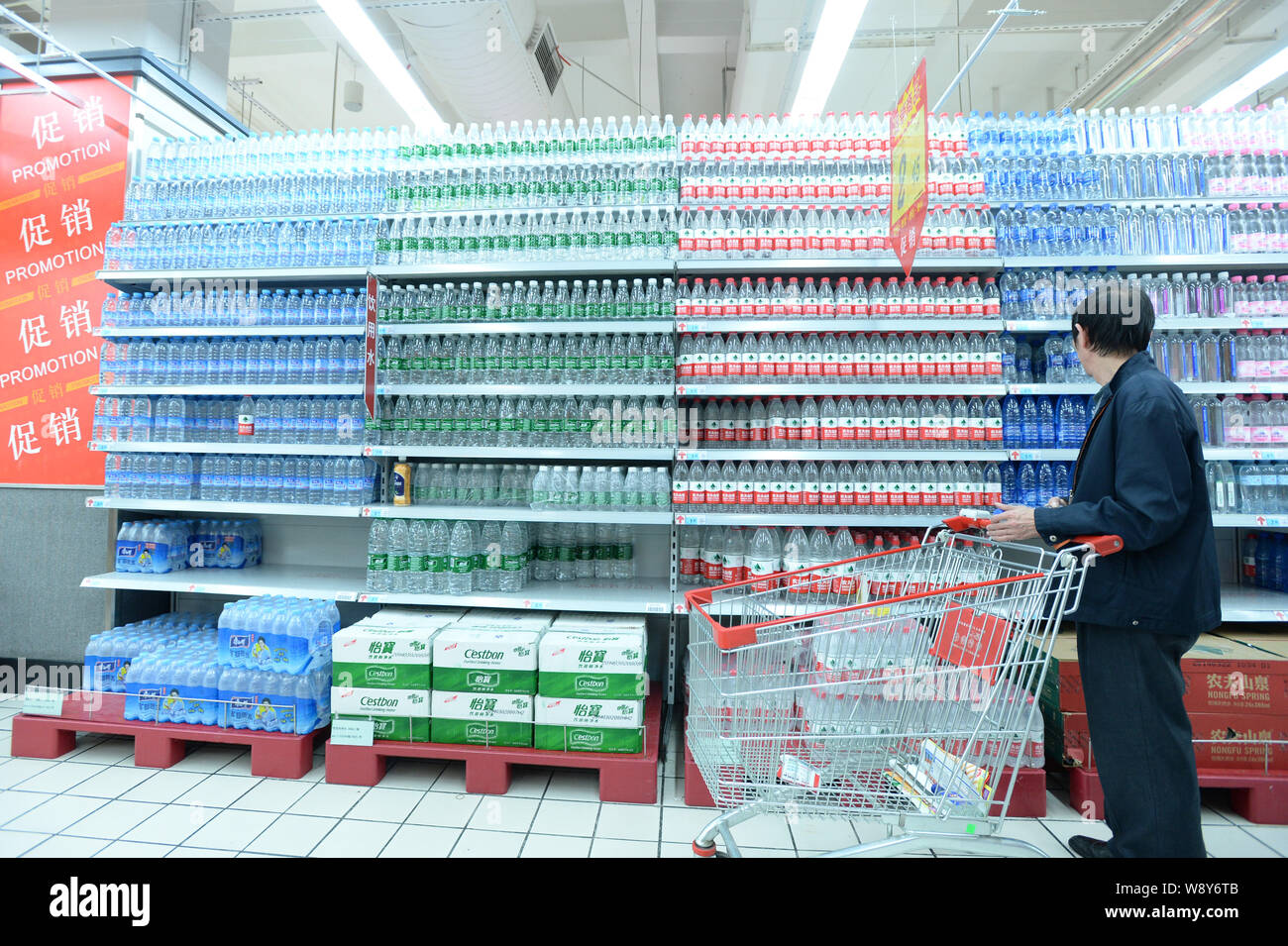 Ein Kunde sucht in Flaschen von reinem Wasser in einem Supermarkt in Wuhan City, Central China Provinz Hubei, 24. April 2014. Zwei große Wasserversorger i Stockfoto
