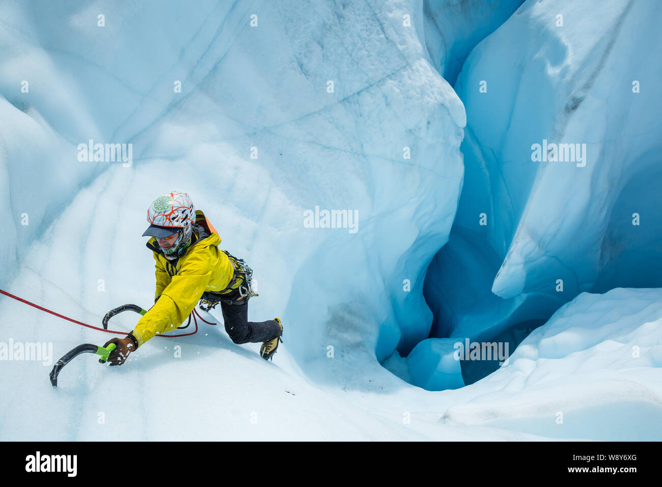 Gletscherführer klettern aus eine große Blue Hole oder Moulin in der Matanuska Gletscher in Alaska. Stockfoto
