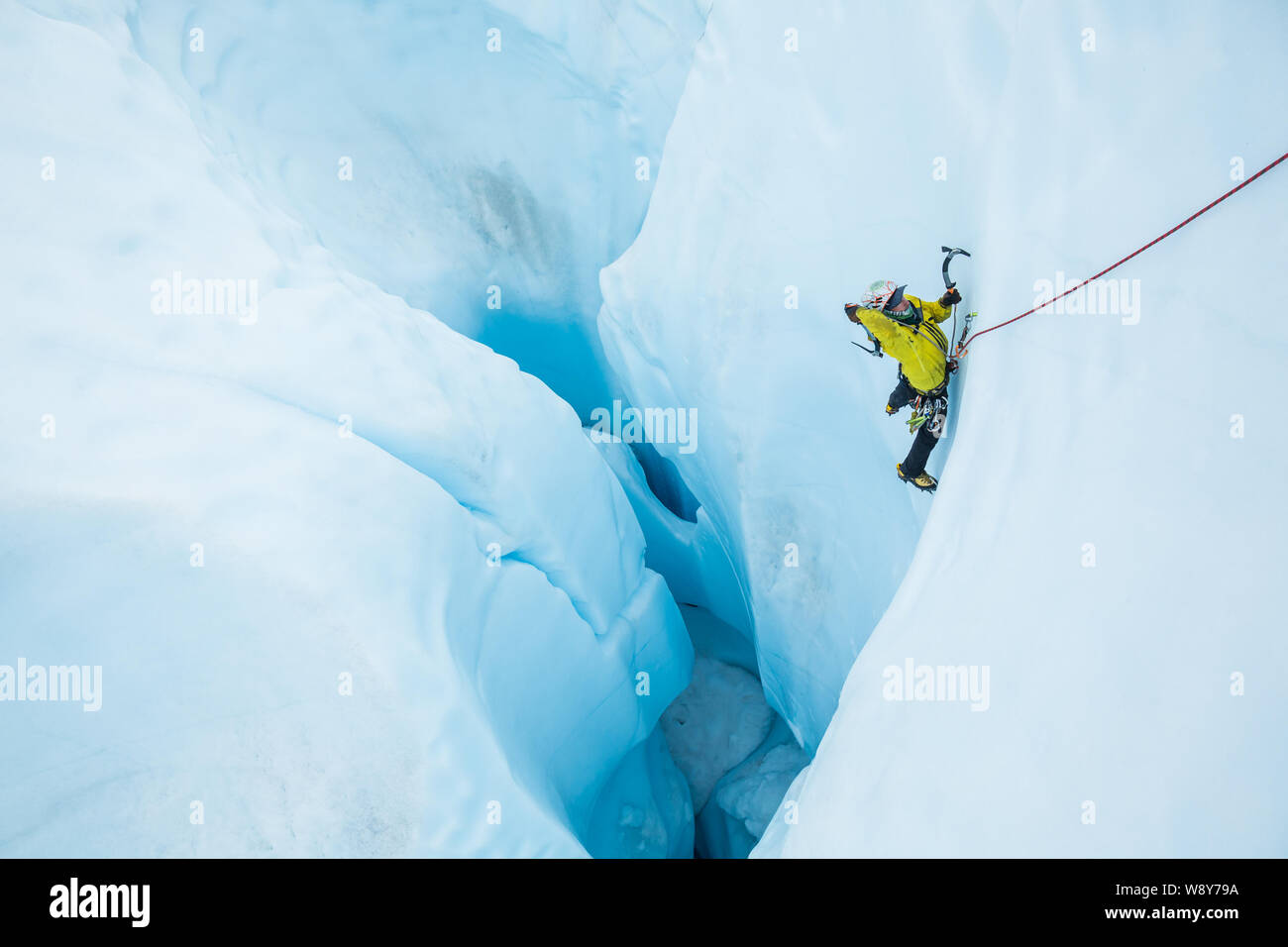 Man schwingen ein Eis, als er aus einer großen Moulin auf der Matanuska Gletscher in Alaska klettert. Stockfoto
