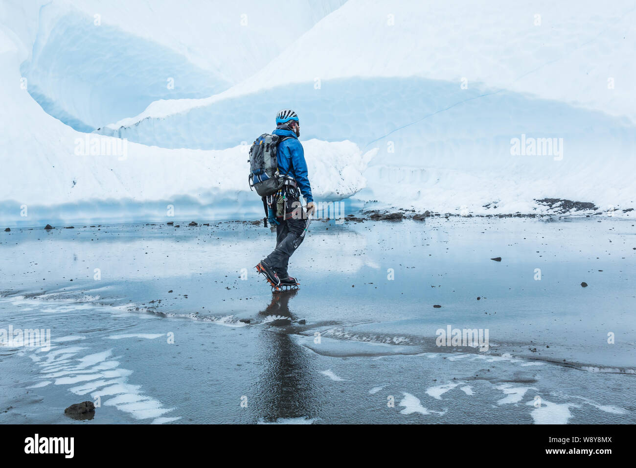 Gletscherführer immer geregnet, da geht er über große Schlamm flach auf der oberen Matanuska Gletscher in Alaska. Stockfoto