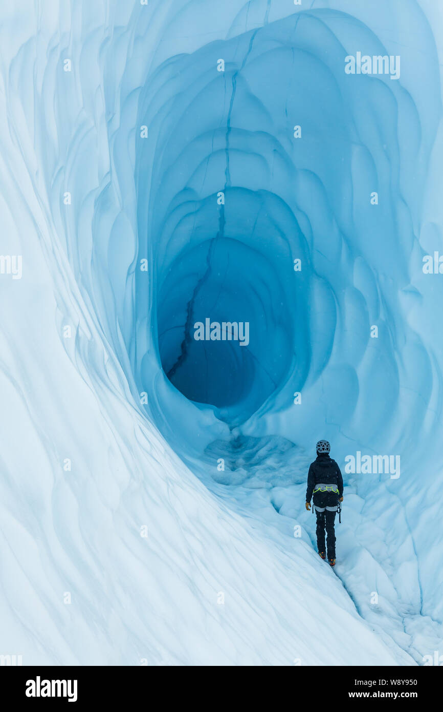Frau gehen in einer Eishöhle im Rahmen einer geführten Reise zu den Matanuska Gletscher in Alaska. Stockfoto