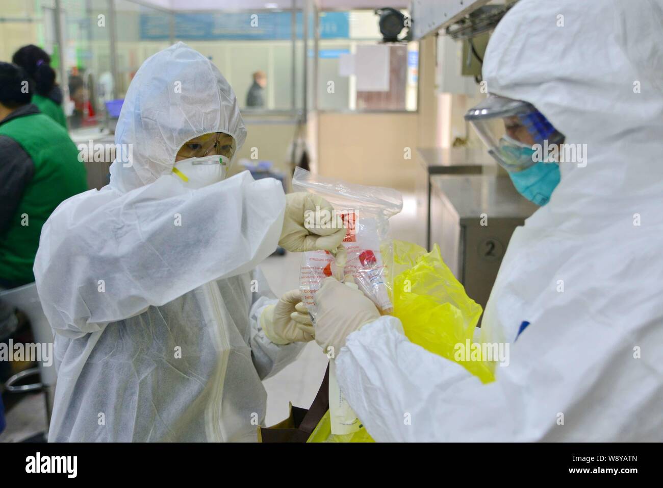 Mitarbeiter aus dem Bezirk Hongkou Zentrum für Krankheitskontrolle und Prävention tragen Schutzanzüge und Gasmasken Proben von Geflügel für Vogelgrippe sammeln Stockfoto