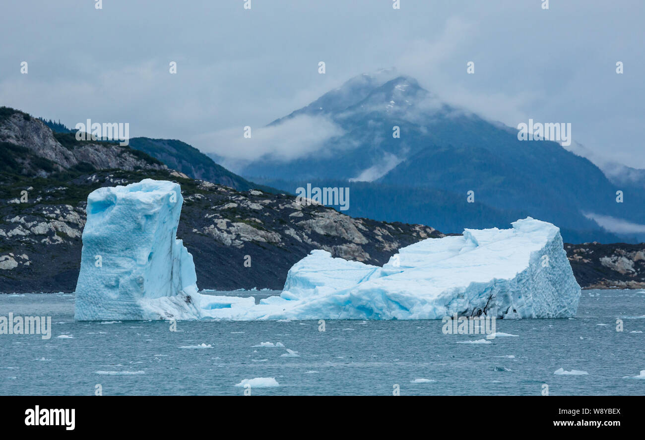 Groß, blocky Eisberg schwebt in den Prince William Sound in der Nähe von Valdez, Alaska. Im Hintergrund ein hoher Peak erhält im Nebel verloren. Stockfoto