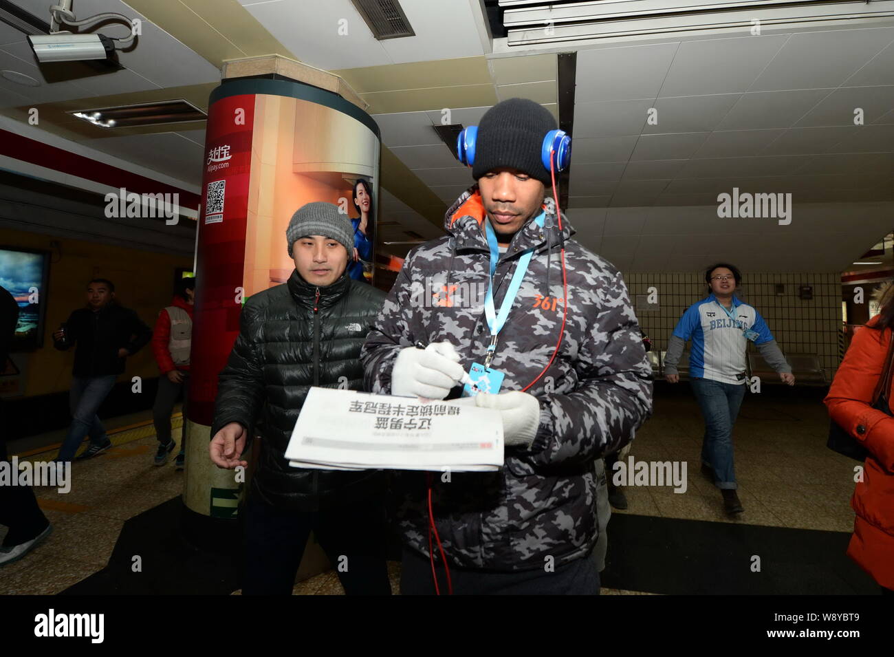 Der ehemalige NBA-Star Stephon Marbury von Peking Enten Basketball Club, front, Autogramme für einen Lüfter in einer U-Bahn-Station der Pekinger U-Bahn der Linie 1 in Beiji Stockfoto