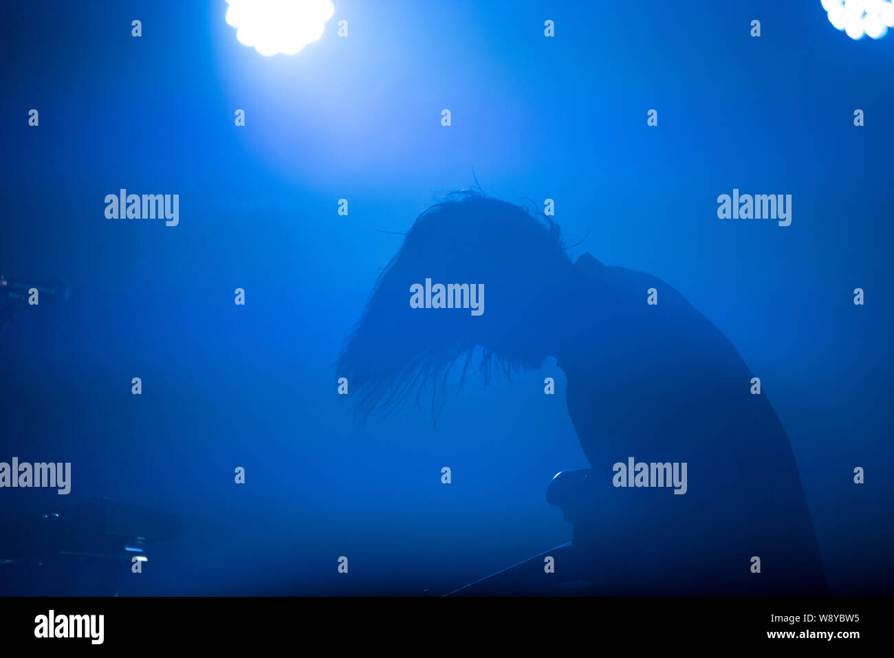 Silhouette eines Gitarristen in blau Bühne leuchtet Stockfoto