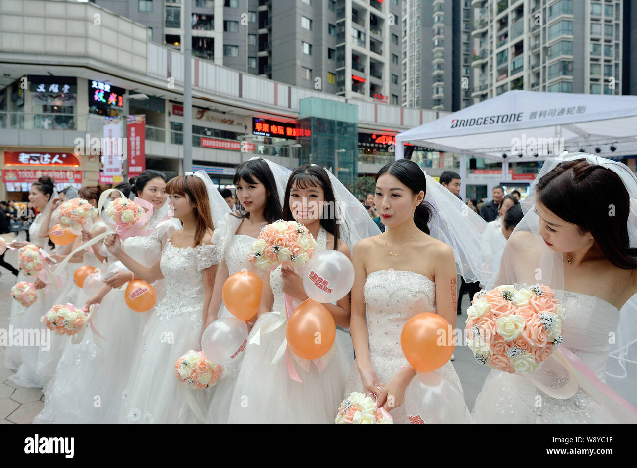 Einzelne Frauen in Hochzeit Kleider gekleidet halten Blumensträuße und Luftballons vor Singles Tag am Wanda Square in Chongqing, China, 9. November 20. Stockfoto