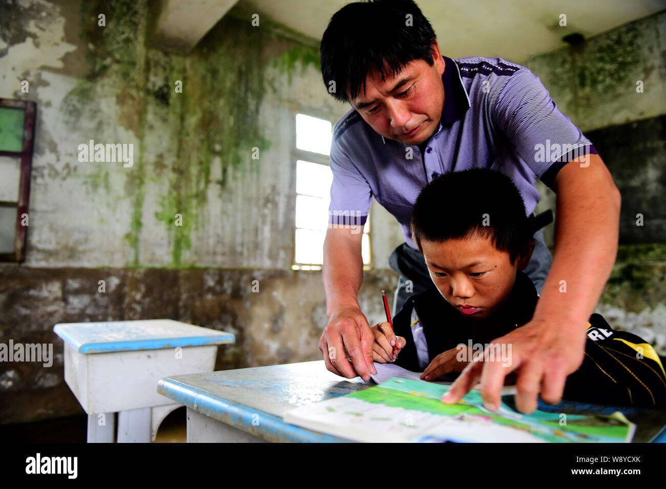 Chinesische Lehrer Xie Daoyu leitet seine einzige Studentin Wang Haixiang Chinesische phonetische Alphabete in den Unterricht an der Grundschule in Sanhe B lernen Stockfoto