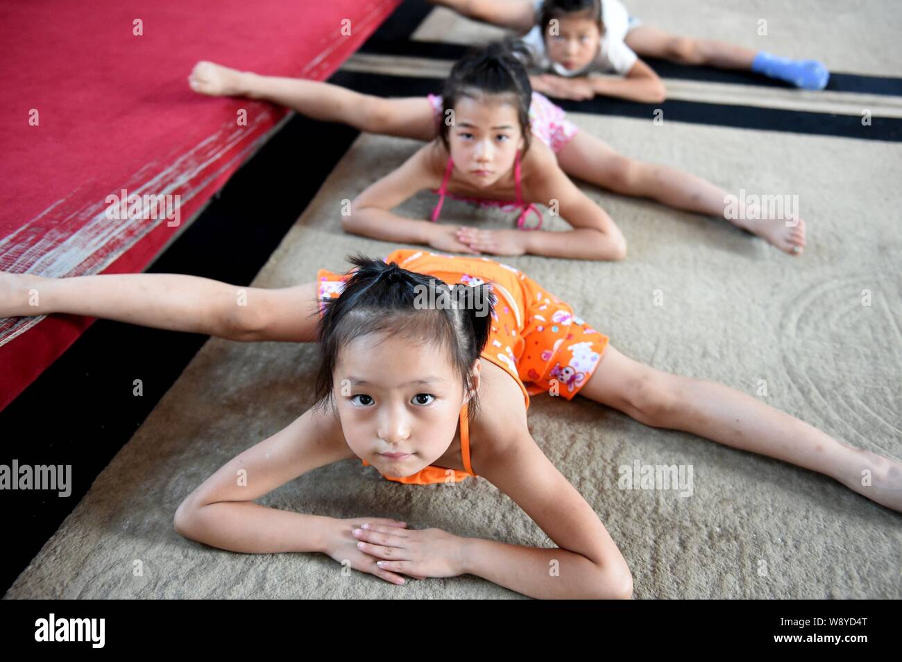 Junge chinesische Mädchen ihren Körper verbiegen und den Spagat auf dem Boden der Gymnastik an einer Gymnastik Training Center in Stadt Bozhou zu üben, East China Stockfoto