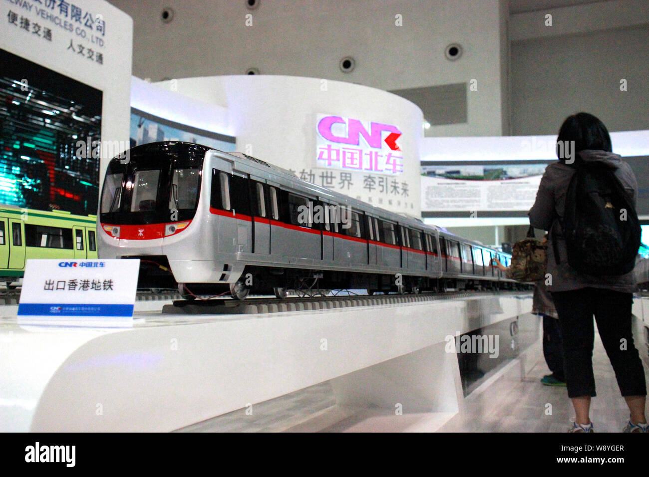 ---- Ein Besucher schaut auf ein Modell U-Bahn auf dem Stand des CNR (China Northern Lok- und Rollmaterial Industry (Group) Corporation) während Stockfoto