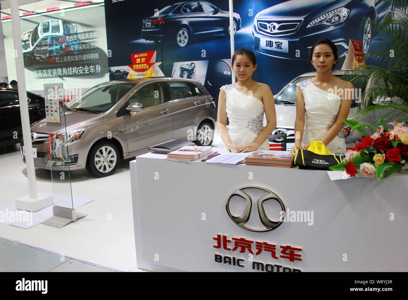 ------ Mitarbeiter sind auf dem Stand von baic Motor gesehen (Beijing Automotive Industry Holding Co., Ltd.) Während ein Automobil Ausstellung in Stadt Haikou, Stockfoto