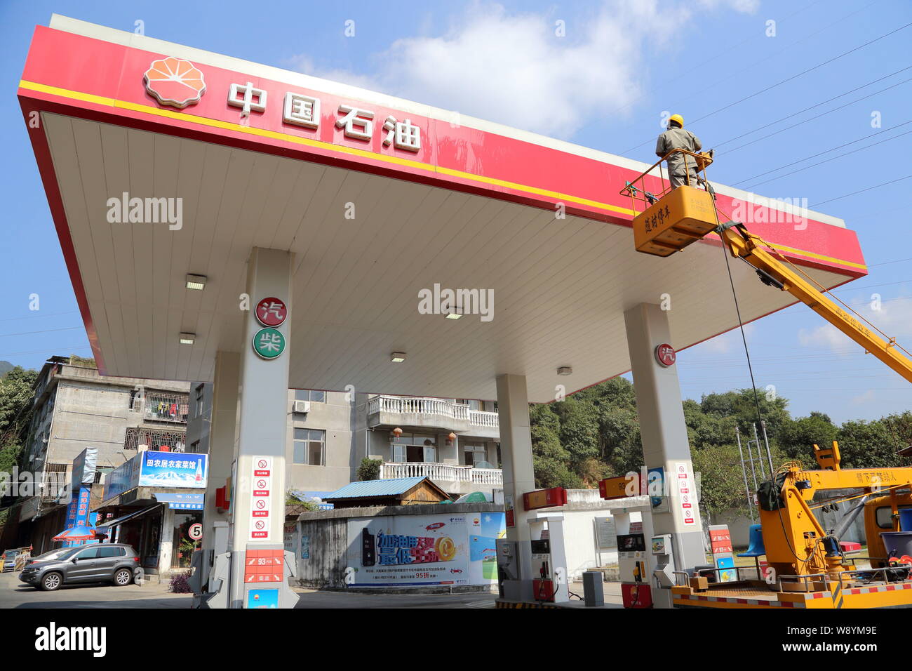 ---- Ein chinesischer Arbeiter reinigt die Tafel an einer Tankstelle von PetroChina, eine Tochtergesellschaft der CNPC (China National Petroleum Corporation), in Fuzhou c Stockfoto