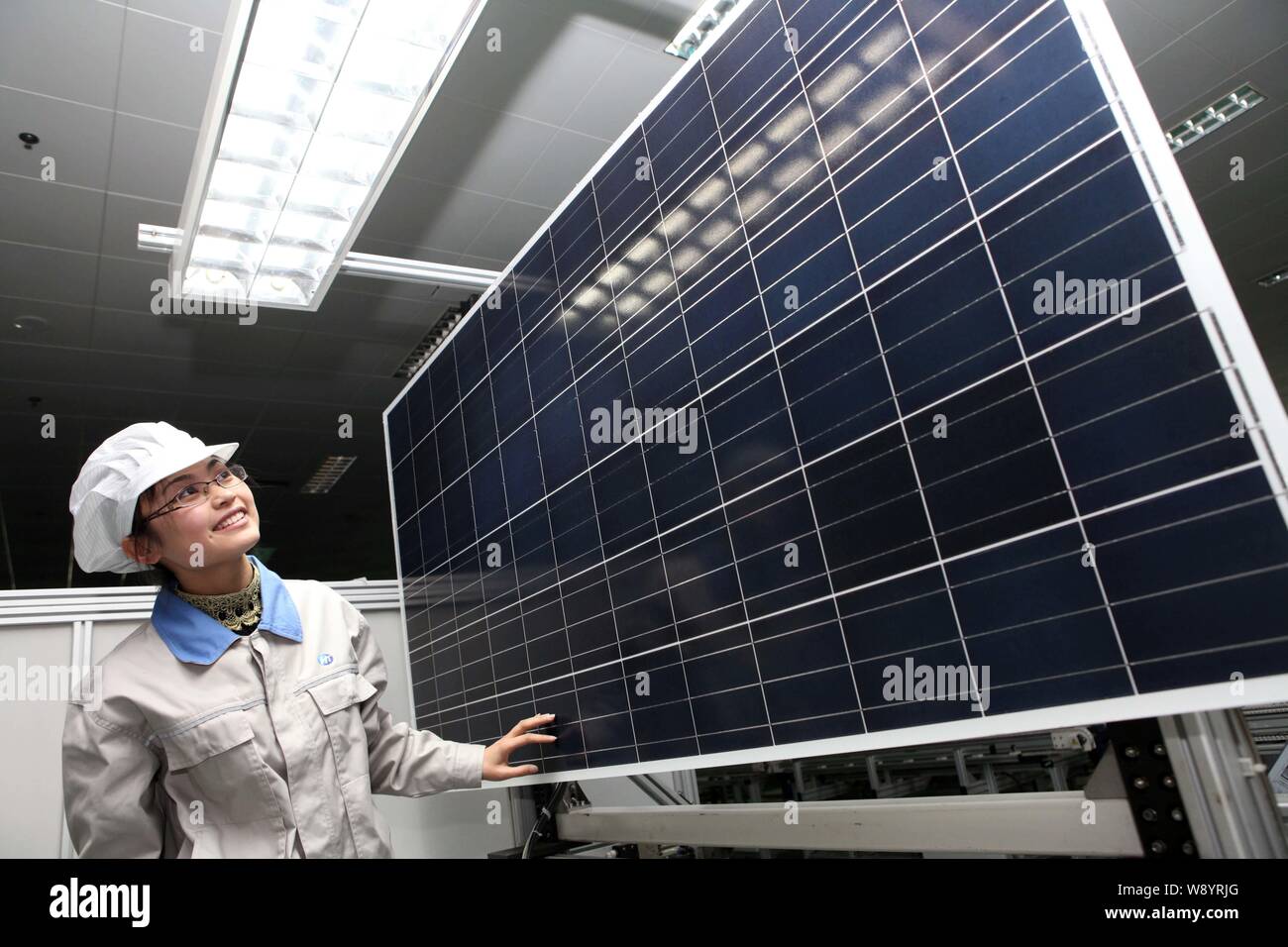---- Eine weibliche chinesischer Arbeiter untersucht ein Solarmodul nach Europa und in die Vereinigten Staaten im Werk Shanghai Shenzhou neue Energie Dev, die exportiert werden sollen Stockfoto