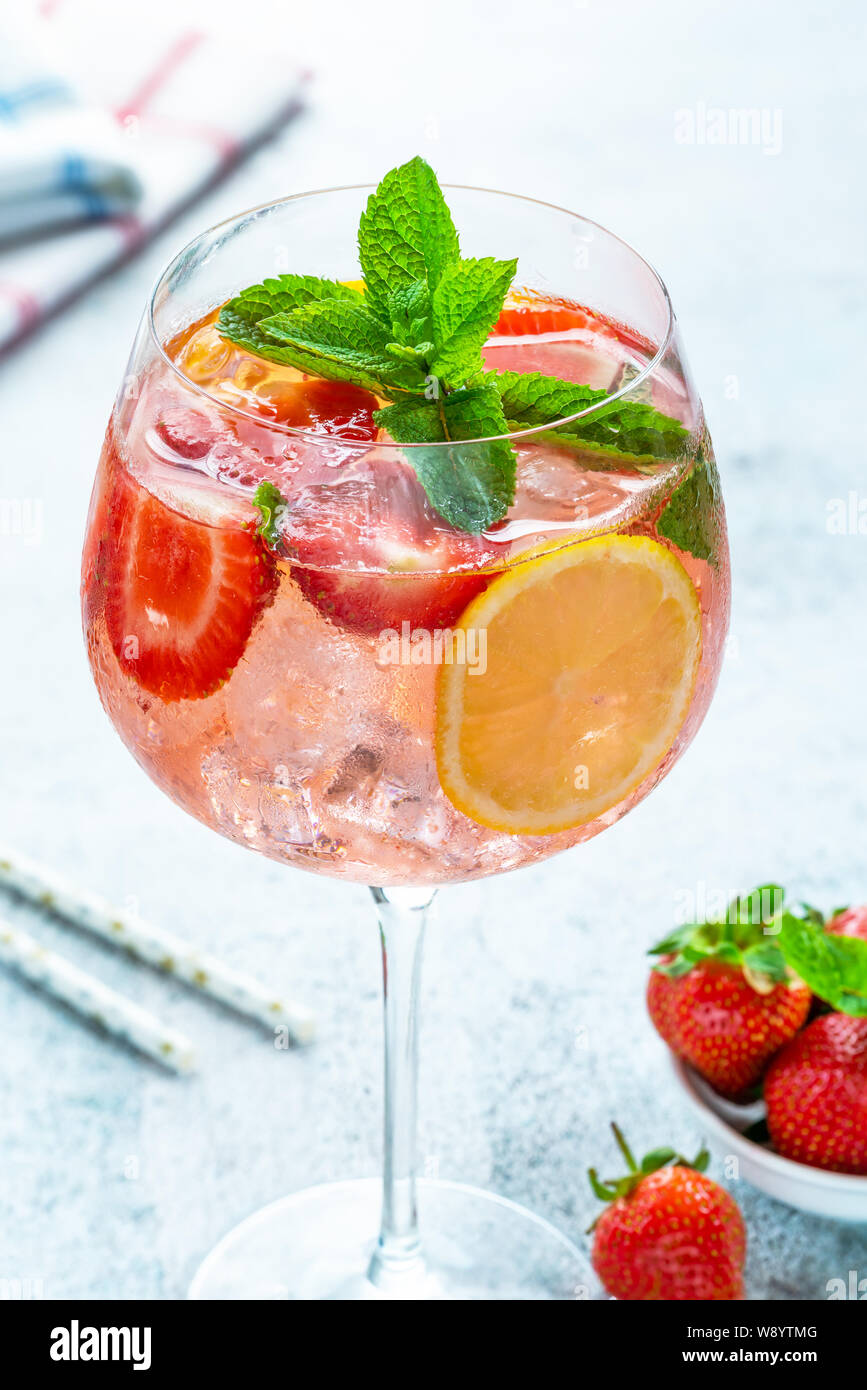 Pink Gin und Tonic Cocktail mit Prosecco und Erdbeeren, garniert mit frischer Minze - Erfrischende Sommer alkoholisches Getränk Stockfoto