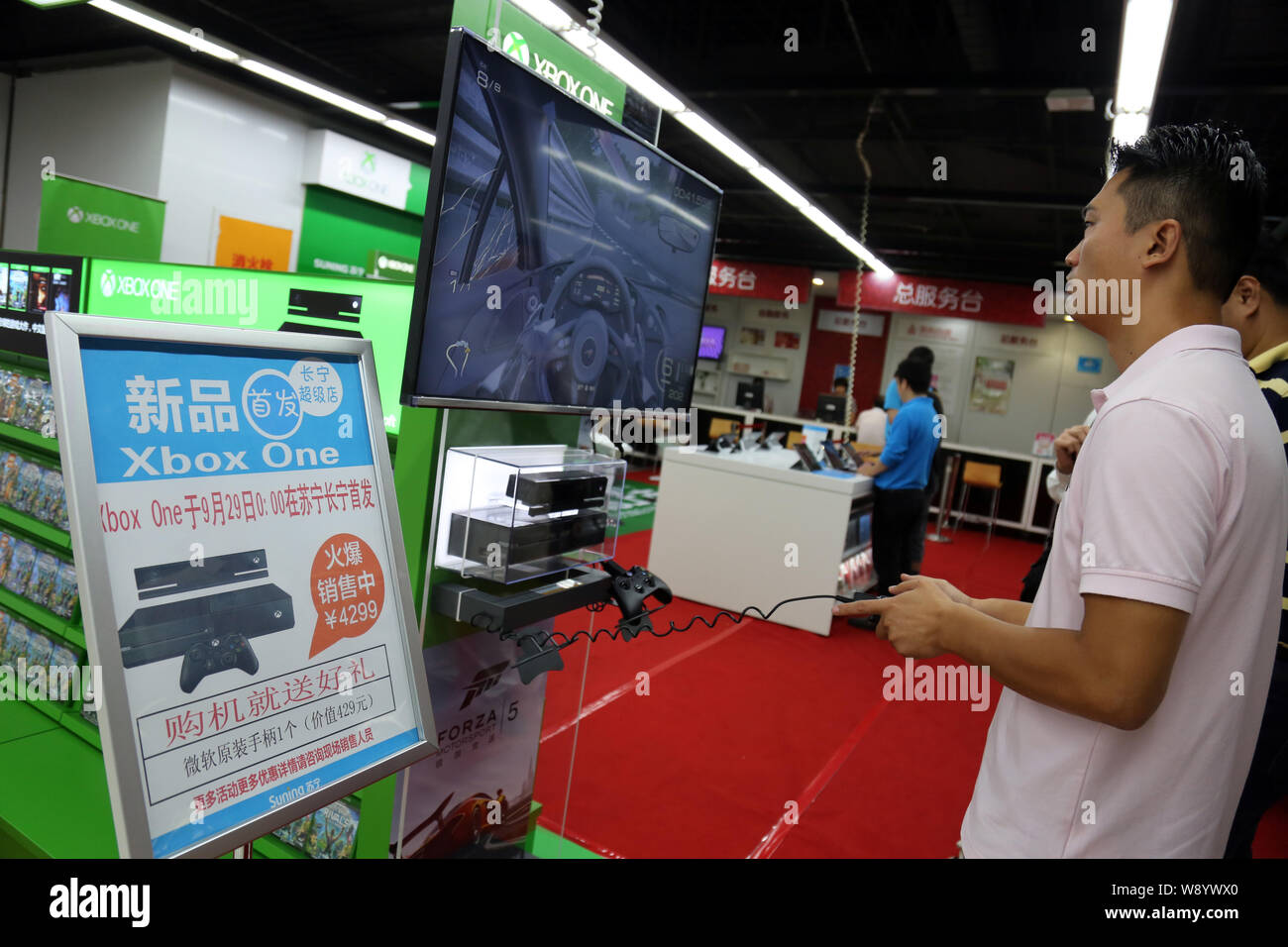 Einen Kunden spielt elektronische Spiele auf einer Xbox eine Spielkonsole zu einem suning Haushaltsgeräte in Shanghai, China, 29. September 2014. Microsoft la Stockfoto