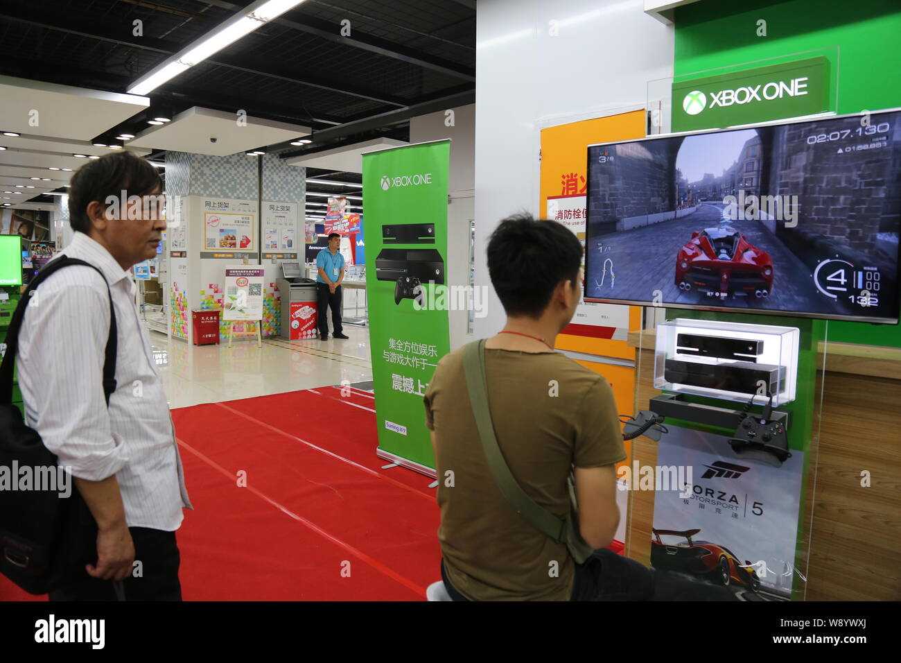 Einen Kunden spielt elektronische Spiele auf einer Xbox eine Spielkonsole zu einem suning Haushaltsgeräte in Shanghai, China, 29. September 2014. Microsoft la Stockfoto