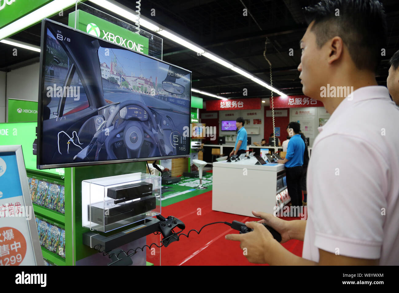 Einen Kunden spielt elektronische Spiele auf einer Xbox eine Spielkonsole zu einem suning Haushaltsgeräte in Shanghai, China, 29. September 2014. Microsoft la Stockfoto