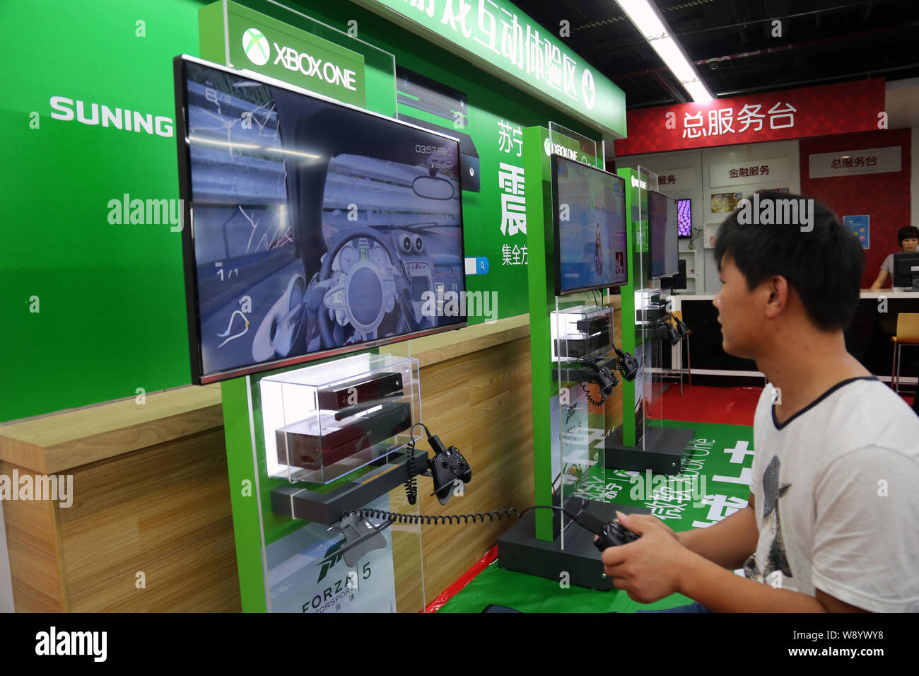 Einen Kunden spielt elektronische Spiele auf einer Xbox eine Spielkonsole zu einem suning Haushaltsgeräte in Shanghai, China, 29. September 2014. Microsoft la Stockfoto
