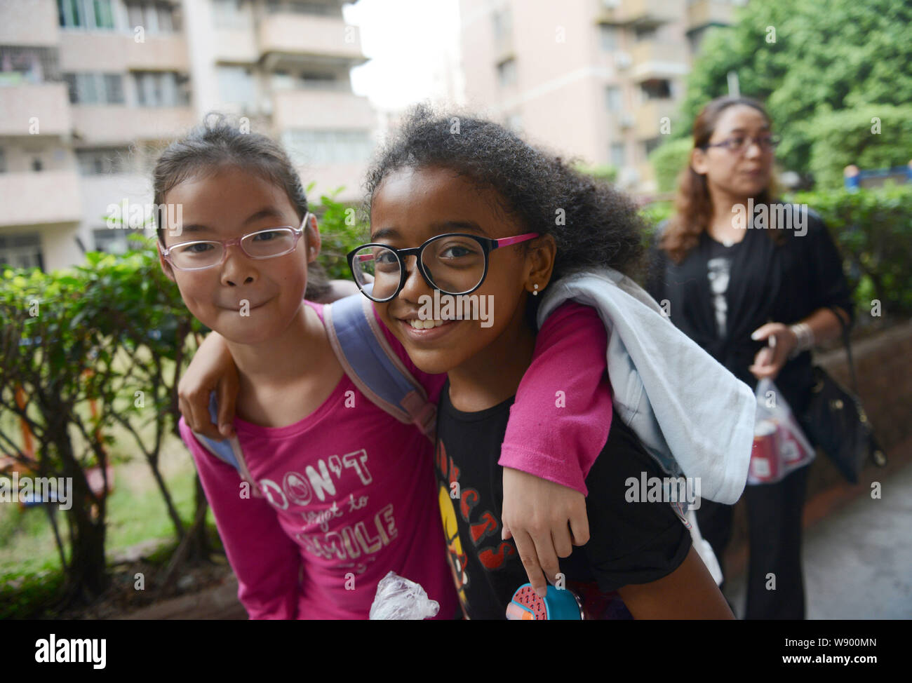Chinesische afrikanisches Mädchen Xiao Xiao, Rechts, und ihre Chinesische  klassenkameradin Pose auf einer Straße nach der Schule in der Stadt  Guangzhou, der südchinesischen Provinz Guangdong, 21N Stockfotografie -  Alamy