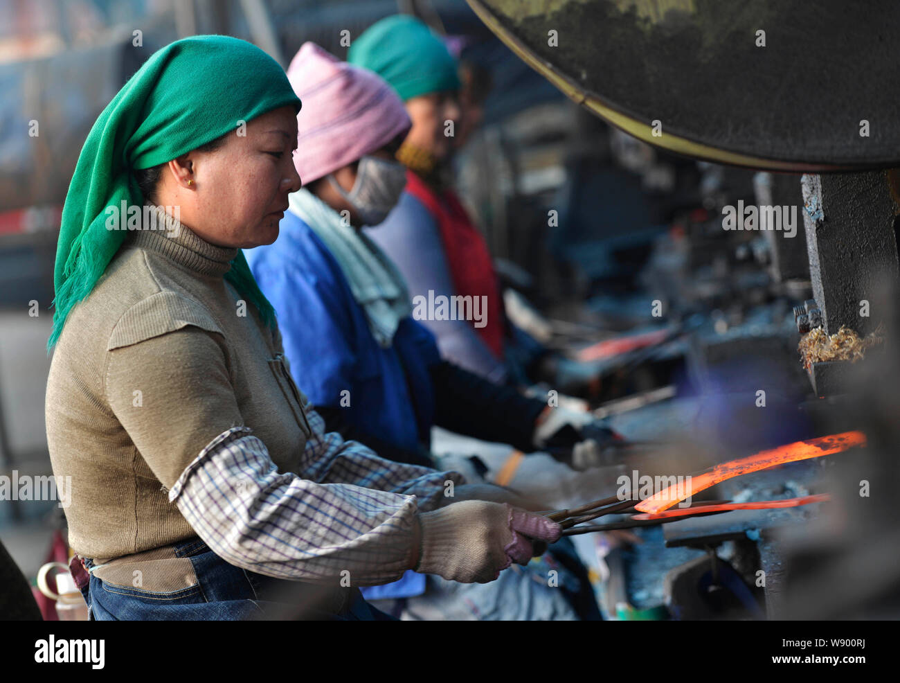 ------ Weibliche chinesische Arbeiter produzieren Teile für Kultivatoren eine Fabrik in Zouping County in der ostchinesischen Provinz Shandong, 12. November 2014. Growt Stockfoto