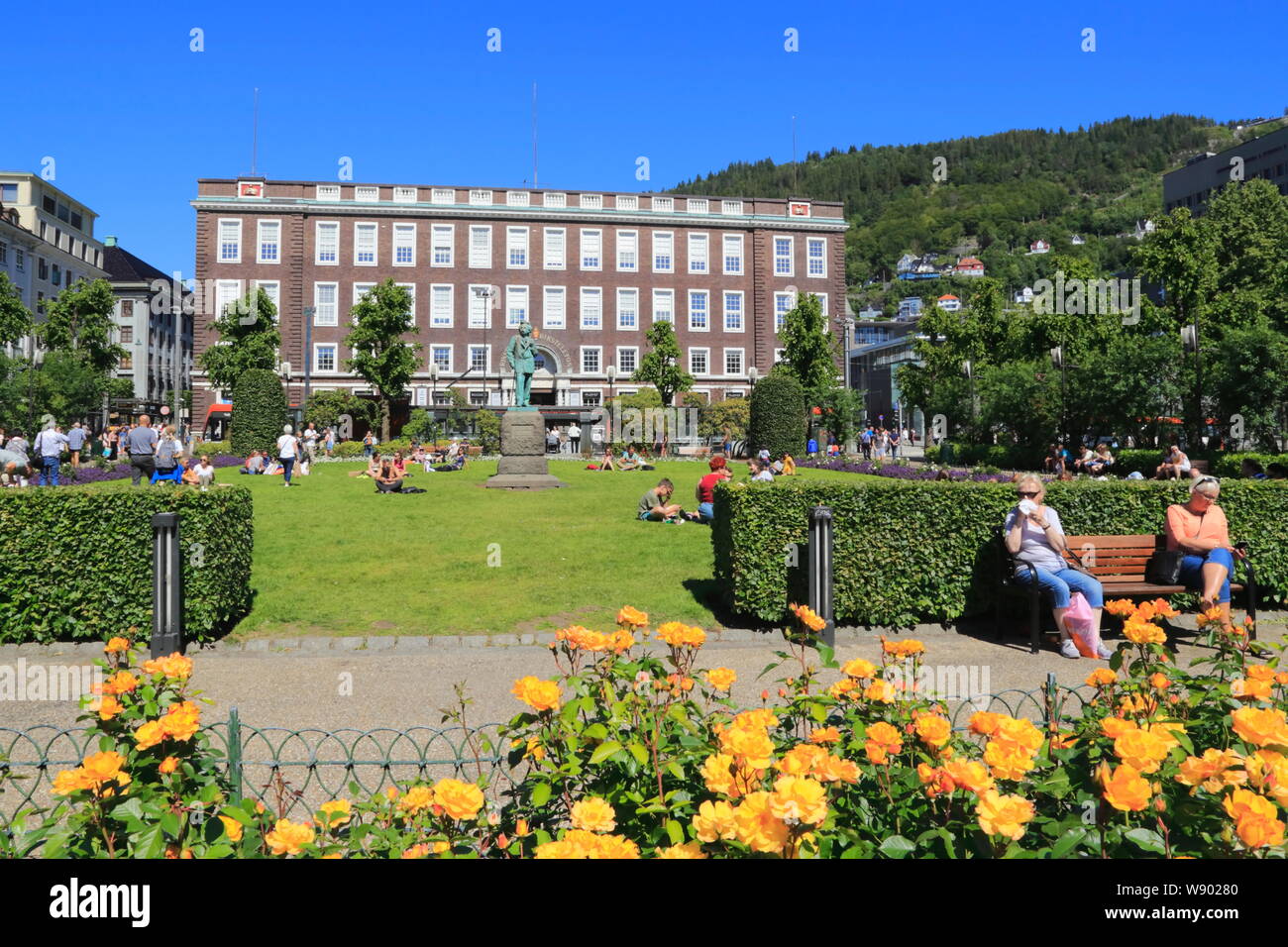 Die Menschen genießen den Sonnenschein in einem kleinen Garten vor dem Telegrafen Shopping Mall in Bergen, Norwegen, im Sommer. Stockfoto