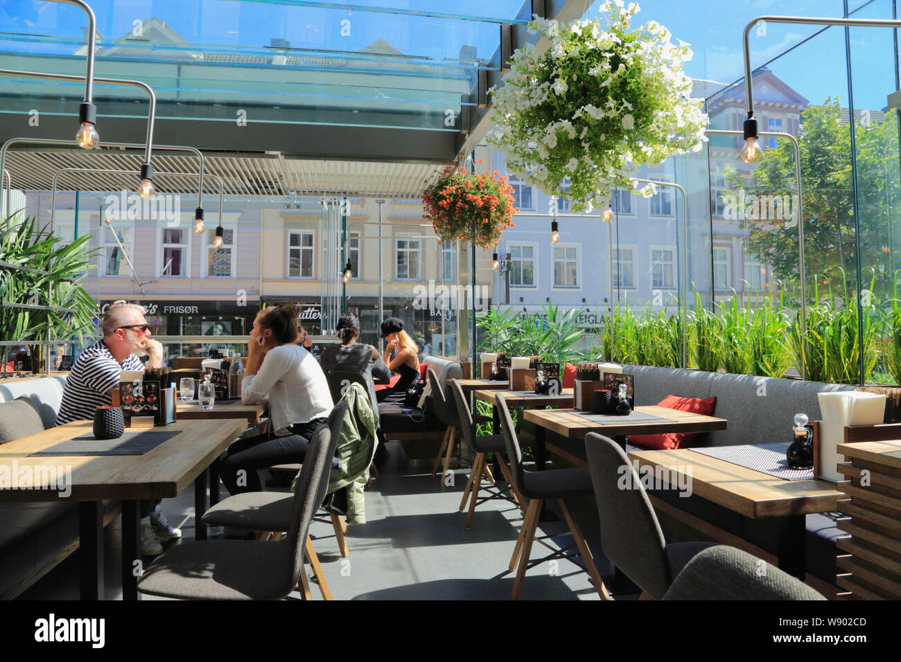 Die Leute sitzen in der Sonne Zimmer (Wintergarten) Bereich der Sumo Restaurant in Bergen, Norwegen. Stockfoto