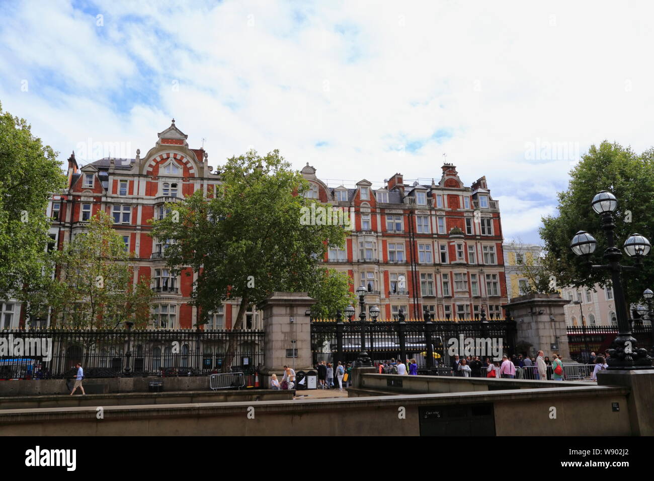 Touristen und Besucher lassen Sie das Britische Museum am Haupttor, gegenüber einem roten Backsteingebäude in Bloomsbury, London, Vereinigtes Königreich. Stockfoto