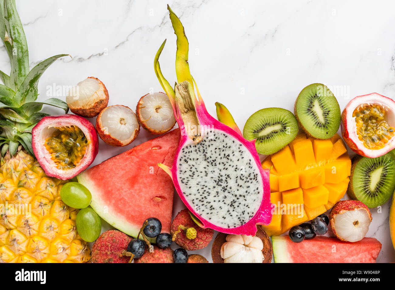 Frische exotische Früchte und tropischen Palmen Blätter auf weißem Hintergrund - Papaya, Mango, Ananas, Maracuja, Drachenfrucht, Melone. Mockup, flach Stockfoto