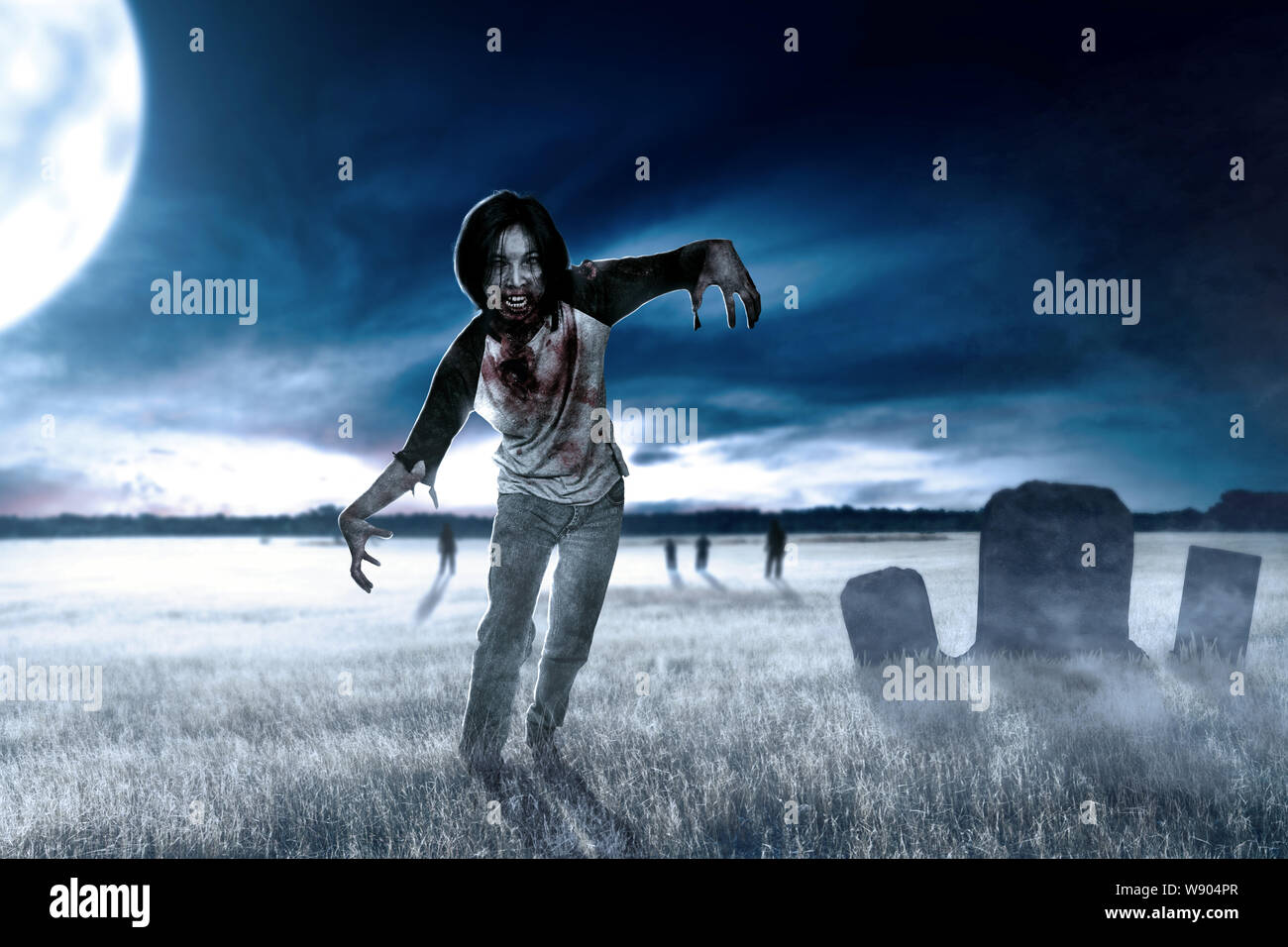 Gruselige Zombies mit Blut und Wunden an seinem Körper herumlaufen auf der Rasenfläche mit einem Grabstein und Mondschein. Halloween Konzept Stockfoto